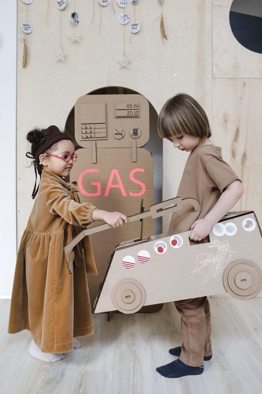 Children playing with DIY cardboard box toys